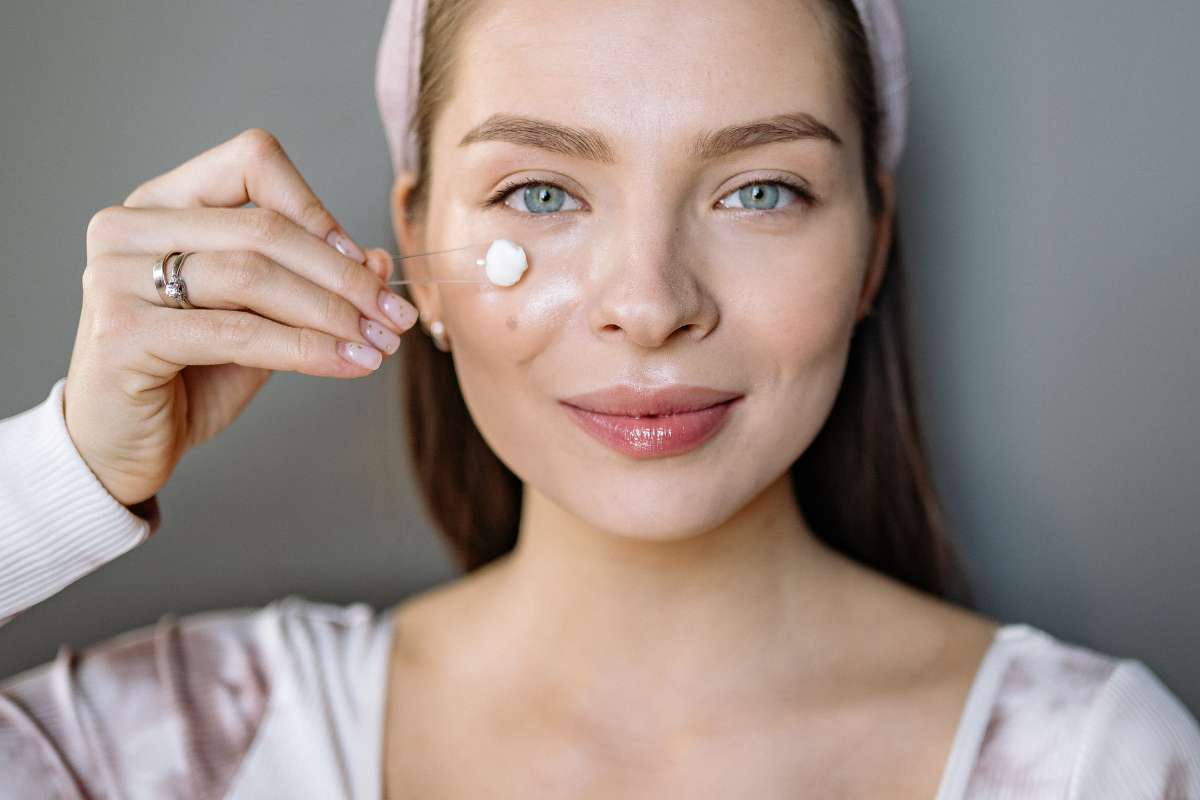 mulher aplicando skincare para reduzir inflammaging e cuidar da pele